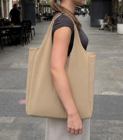 Beige foldable tote worn over the shoulder
