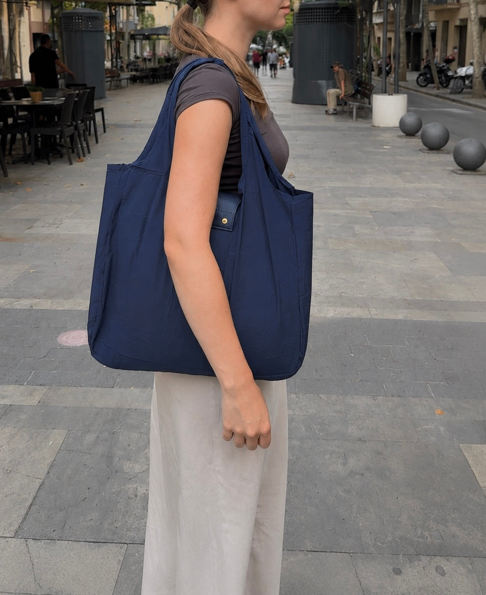 Navy foldable tote worn over the shoulder