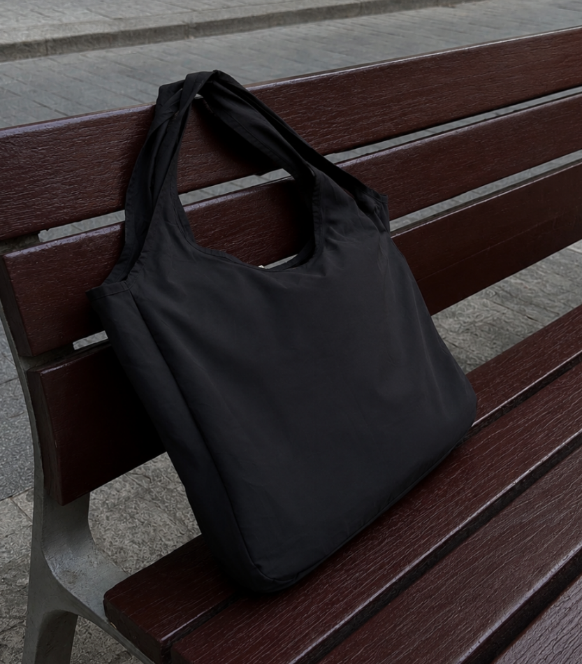 Black foldable tote on a bench