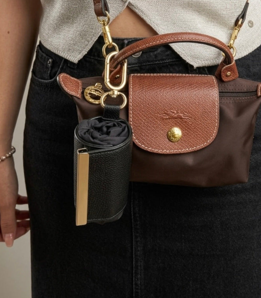 Black compact pouch clipped to handbag