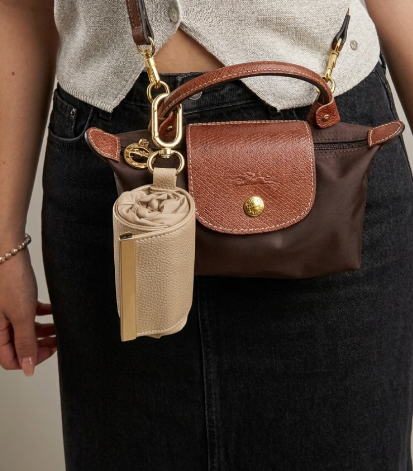 Beige compact pouch clipped to handbag